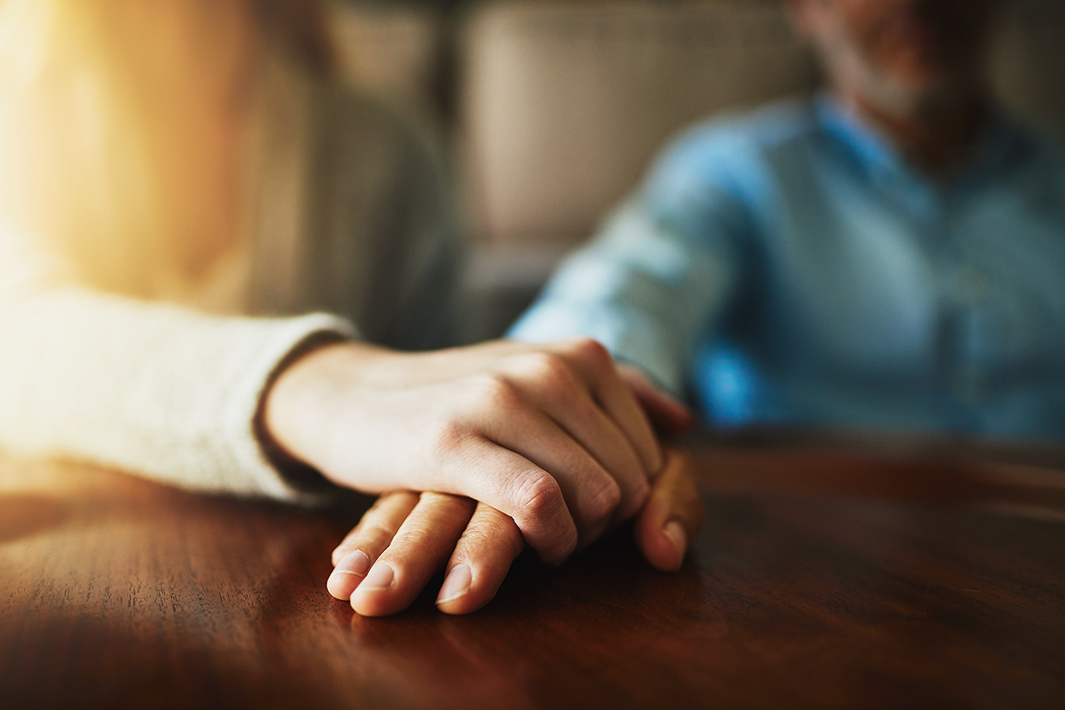 Closeup shot of two unidentifiable people holding hands in comfort